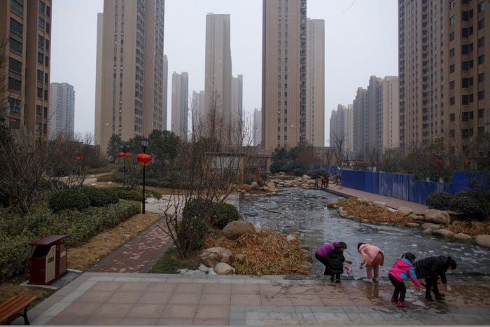 People play with ice floats at a pond in the compound of a apartment complex in Zhengzhou