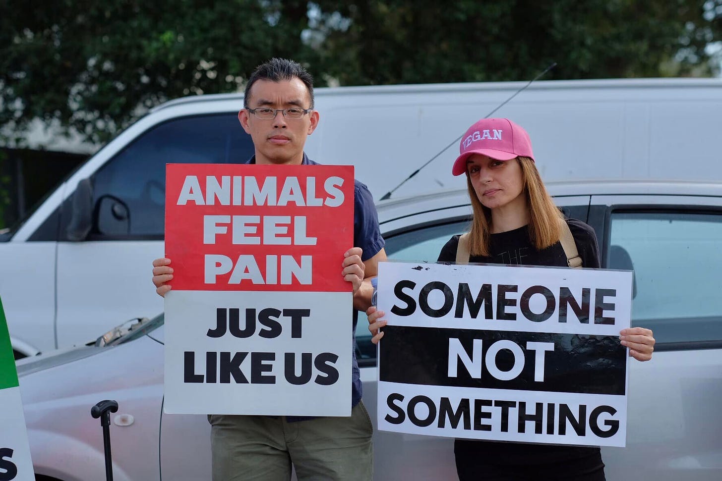 May be an image of 2 people, people standing, outdoors and text that says 'EGAN ANIMALS FEEL PAIN JUST LIKEUS SOMEONE NOT SOMETHING'
