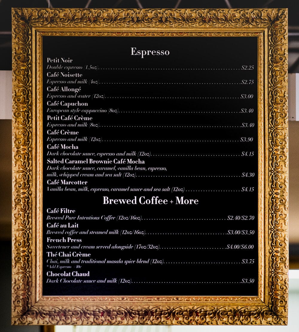 The framed menu for espresso and coffee at Amélie’s French Bakery &amp; Café.
