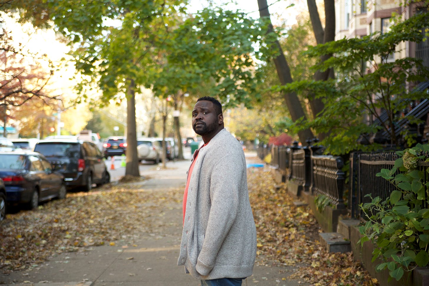 From the film "The Outside Story": A man looks back towards the camera, on a sunny day, as he ponders where to go down the sidewalk.