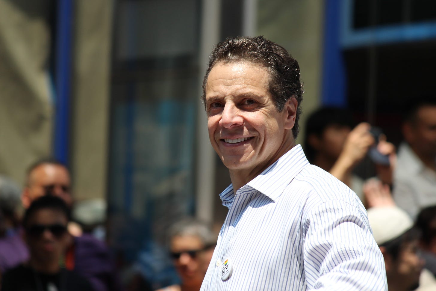 photo of Andrew Cuomo standing on a sunlit NY street