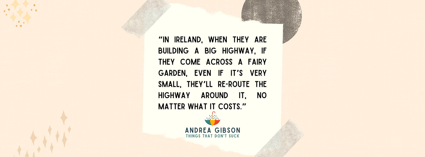 An image of a piece of paper taped to a wall with the text by Andrea Gibson: “In Ireland, when they are building a big highway, if they come across a fairy garden, even if it’s very small, they’ll re-route the highway around it, no matter what it costs” In the background is a cream sky with a black sun and little star sparkles. 
