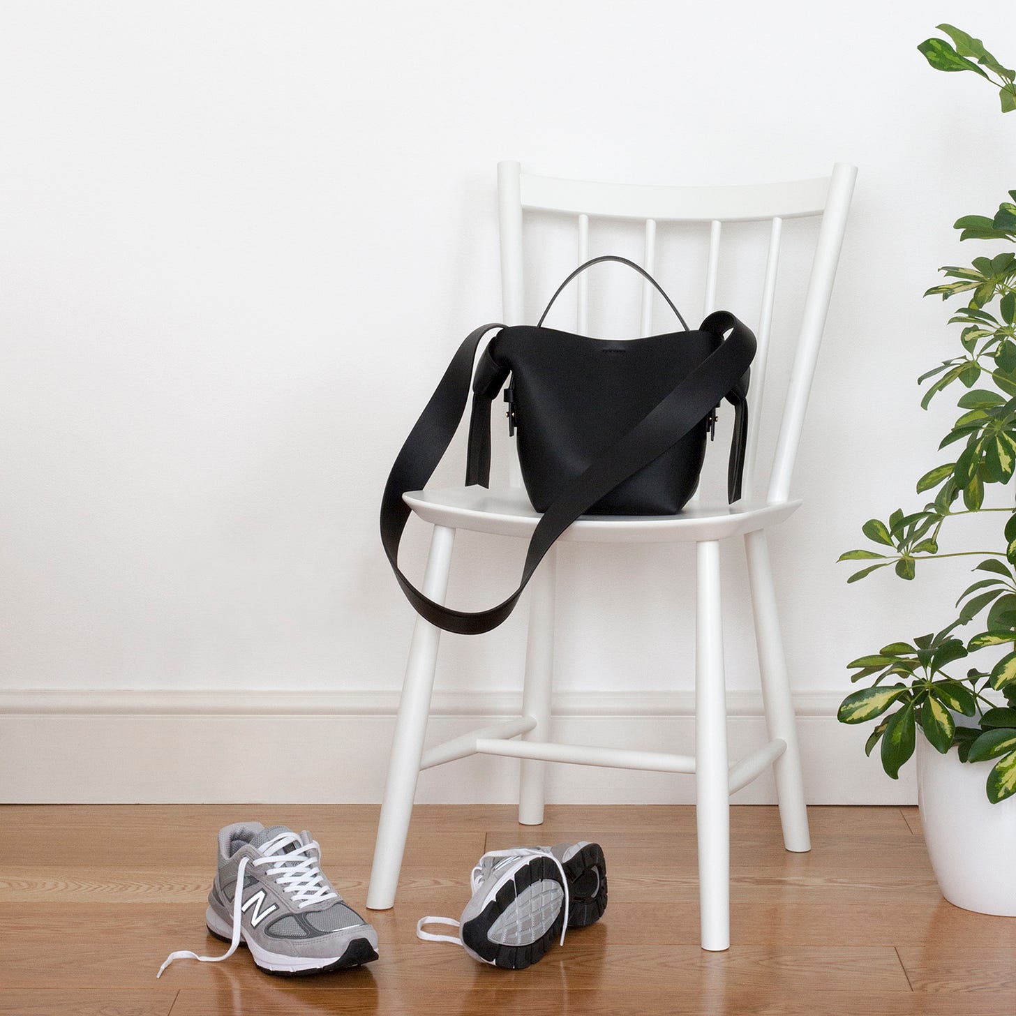 Photo of a white chair, bag and trainers.