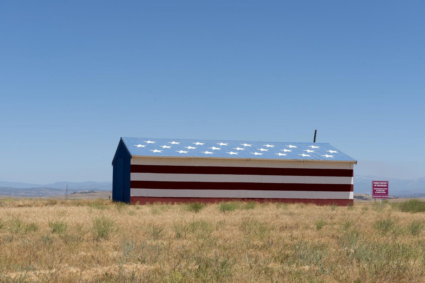 a building is painted like an American flags with stars on the roof and red and white stripes on the side