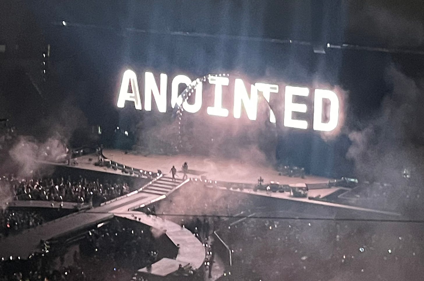 A personal photo taken at Beyonce's Renassiance tour, the stage is clear and the screen says Anointed in all caps and white lettering
