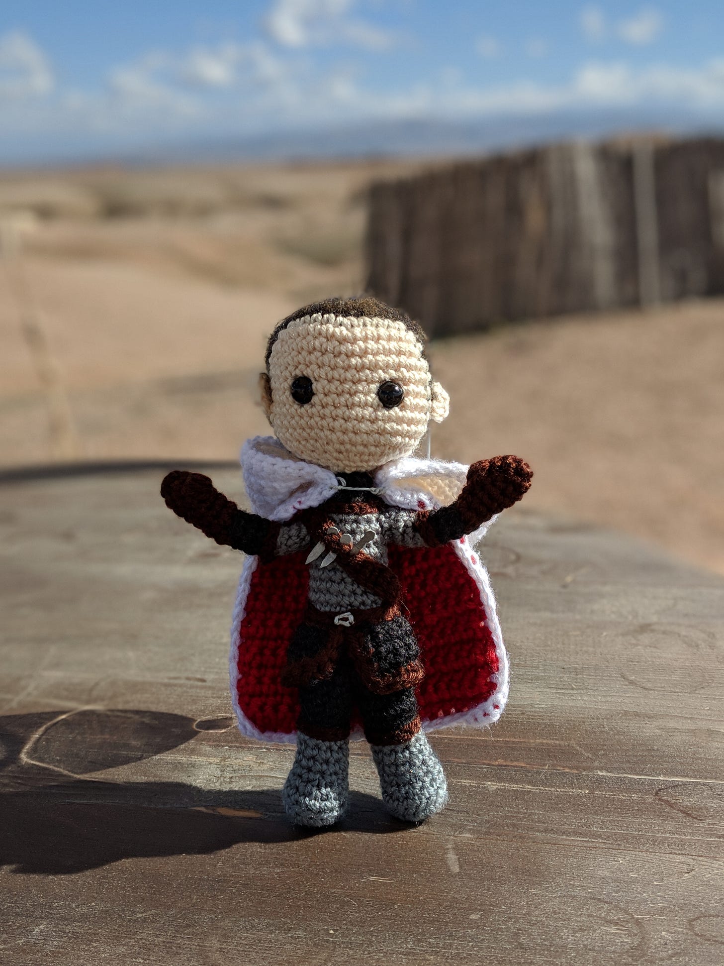 A knitted doll of Aeduan against a desert backdrop in Moroccos