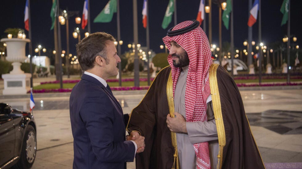 In this photo provided by the Saudi Royal Palace, French President Emmanuel Macron is welcomed by Saudi's Crown Prince Mohammed bin Salman, right, at the Royal Palace in Riyadh, Saudi Arabia, Monday, 