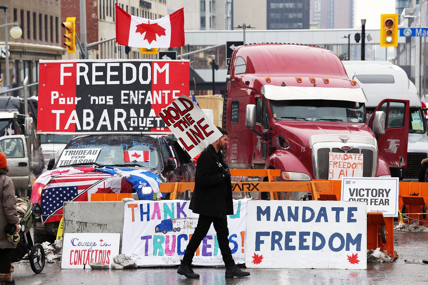 A protester walks in front of parked trucks as demonstrators continue to protest the vaccine mandates implemented by Prime Minister Justin Trudeau in Ottawa, Canada, on February 8.