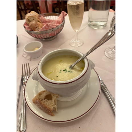 A bowl of soup with a spoon on a plate

Description automatically generated