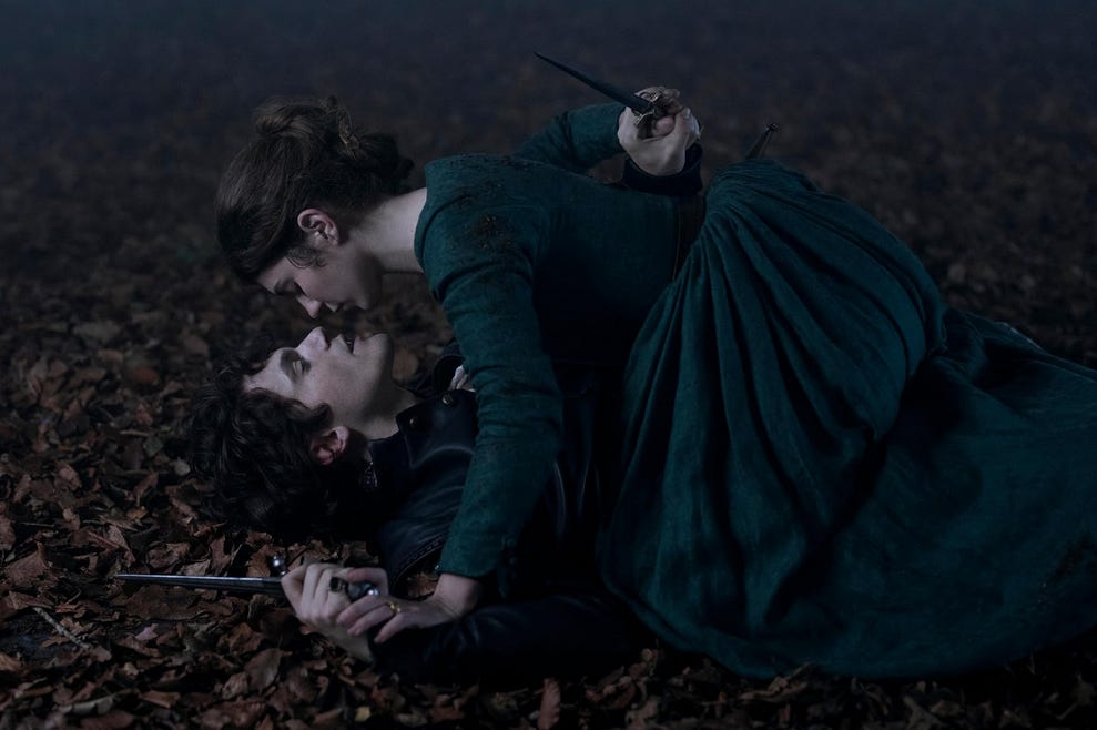 A screenshot from My Lady Jane: Jane has pinned Guildford to the forest floor; both have daggers in their hands and their faces are very close