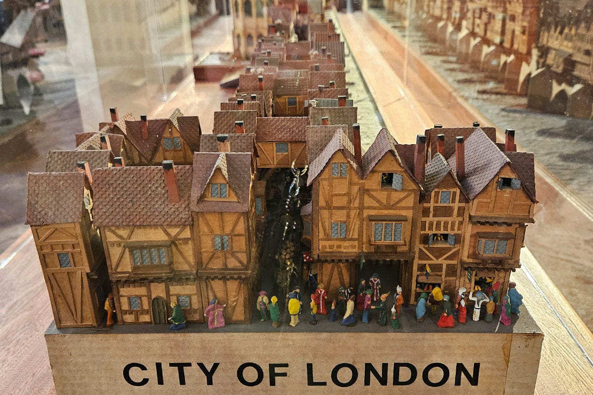 View from the end of a model of a medieval bridge with buildings and people on it. It's labelled City of London.