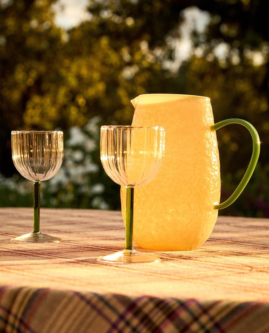 lemon shaped jug with green contrast handle and two glasses in the foreground