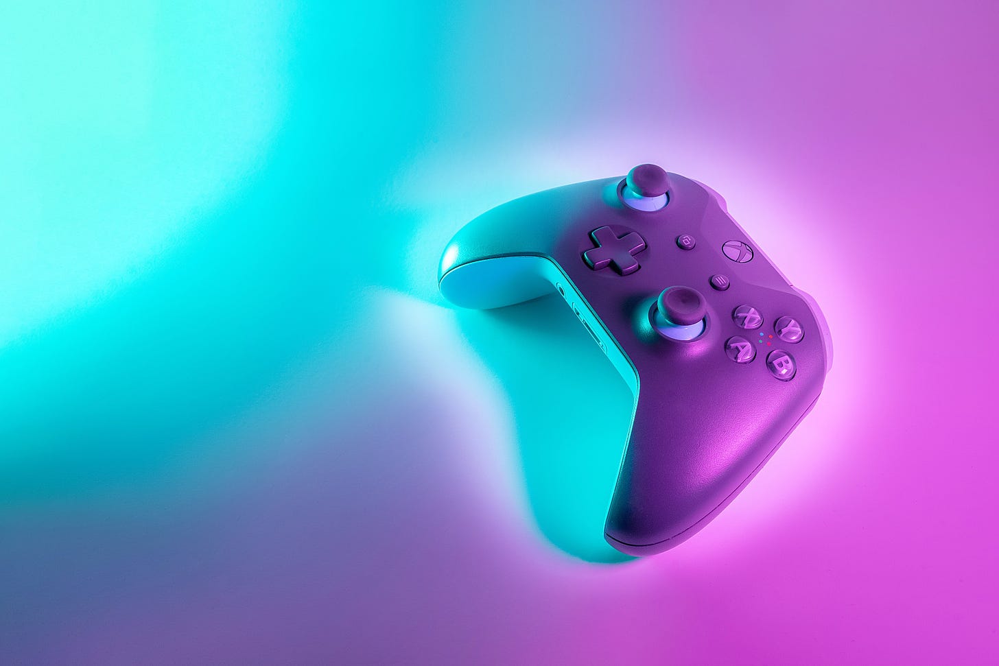 Xbox controller with blue and purple light shining on it