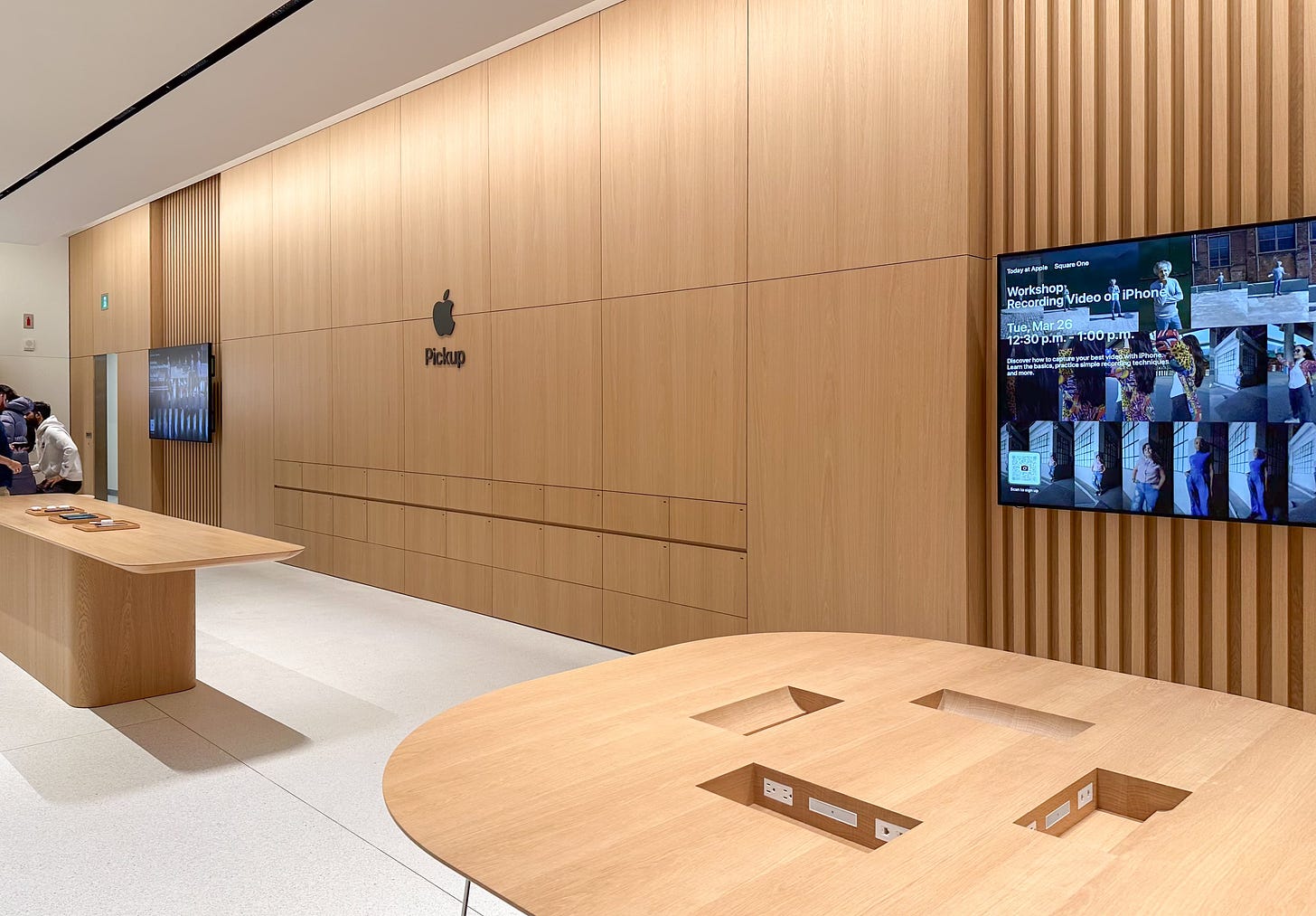 The Apple Pickup Counter, back wall, and Today at Apple tables at Apple Square One.