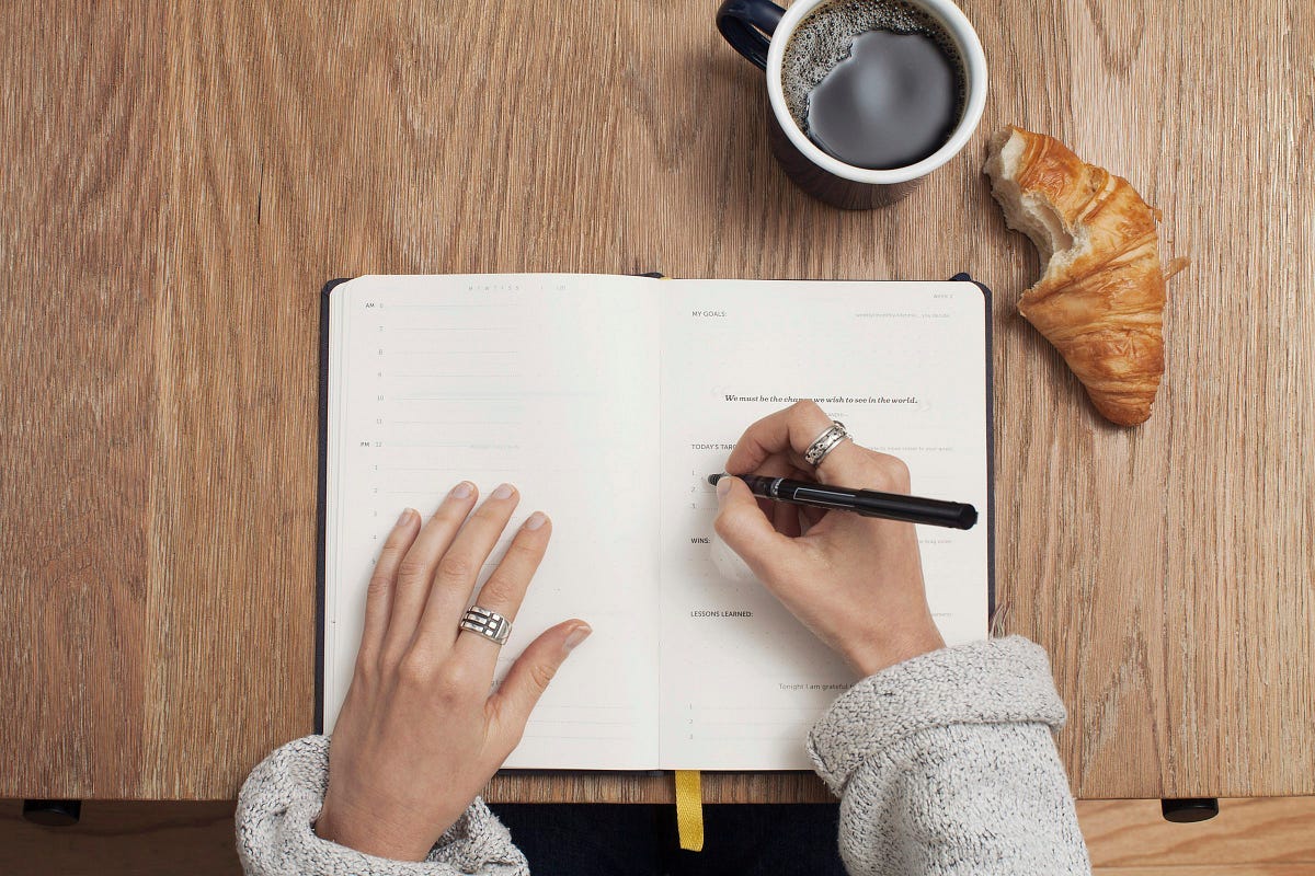 Person writing in a diary. Person writing in a diary.