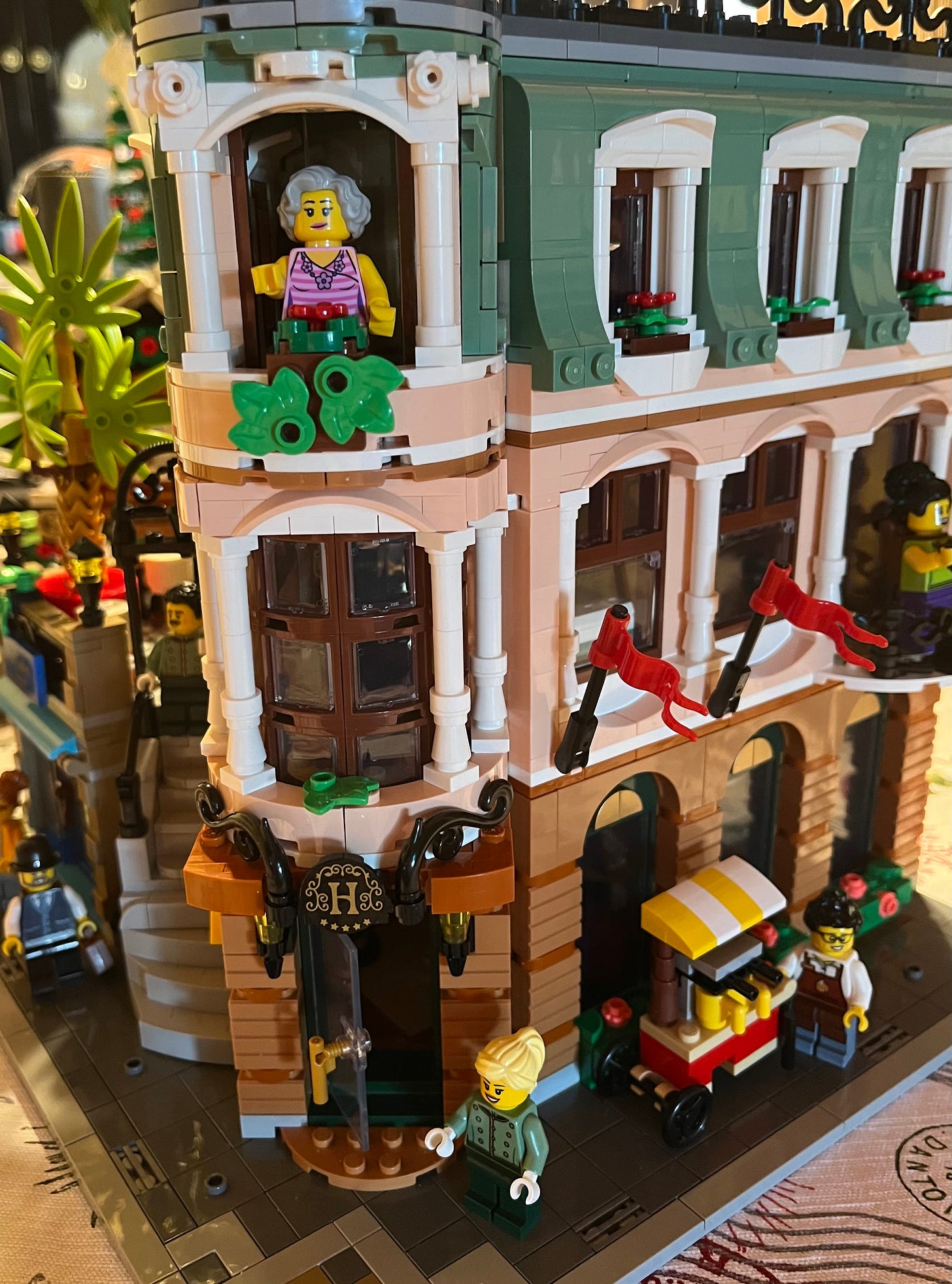 Photo of a LEGO build of a hotel made of pink and green pieces.