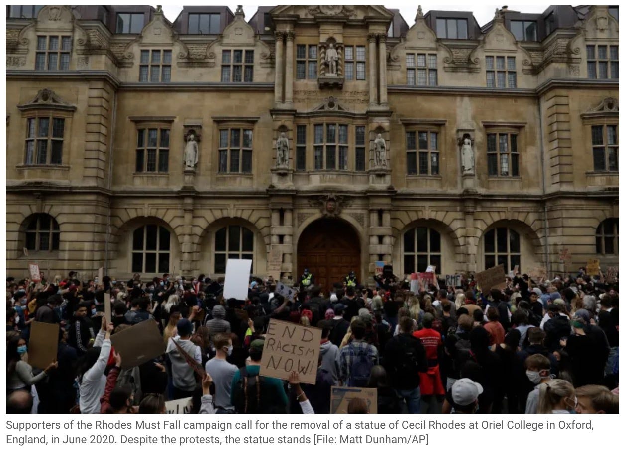 Supporters of the Rhodes Must Fall campaign call for the removal of a statue of Cecil Rhodes at Oriel College in Oxford, England, in June 2020. Despite the protests, the statue stands [File: Matt Dunham/AP]