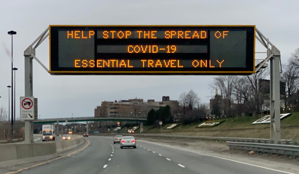 Overpass electronic sign saying help stop the spread of COVID-19, essential travel only