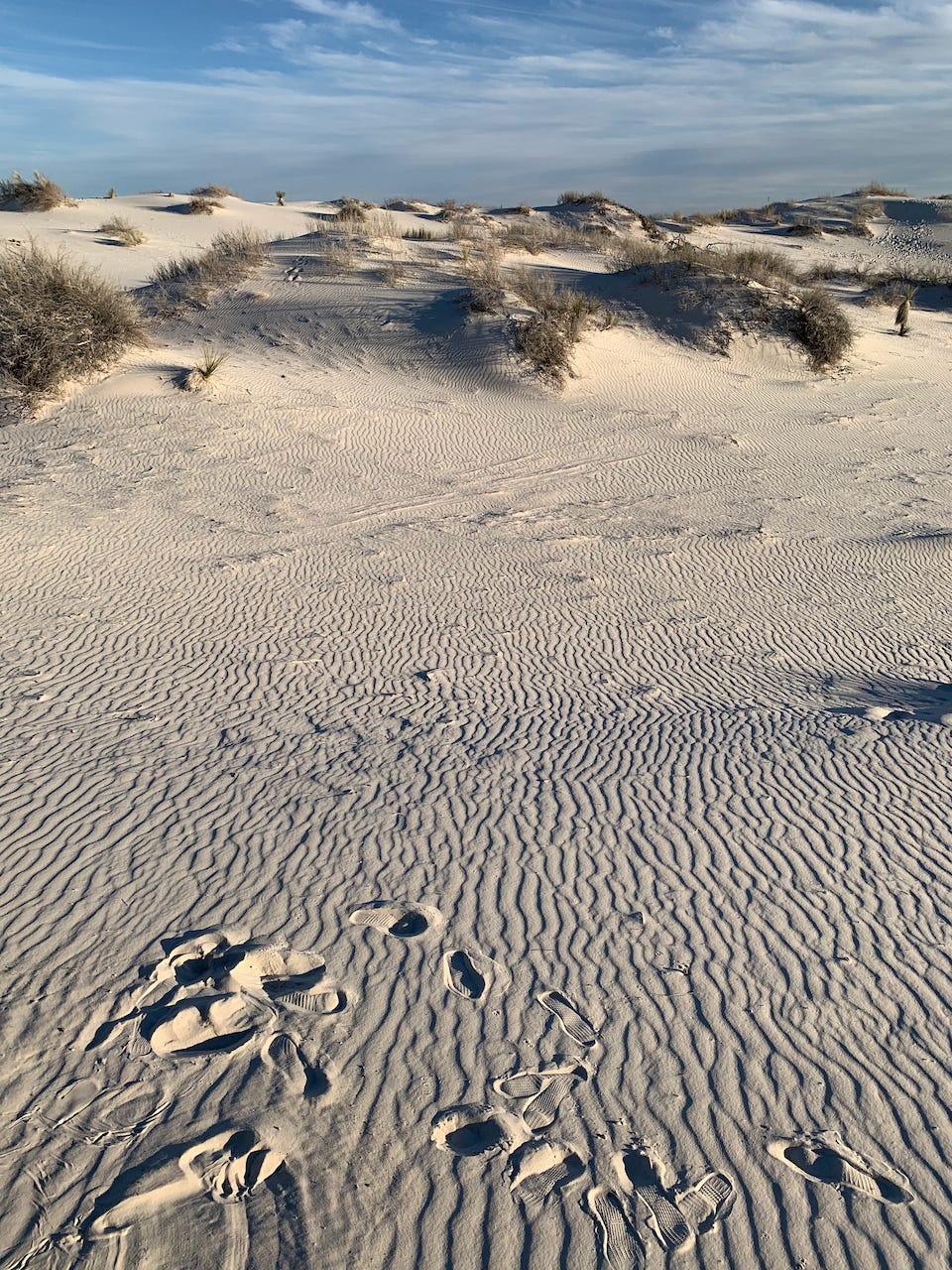 Blue sky with clouds over ripples on sand at White Sands National Park