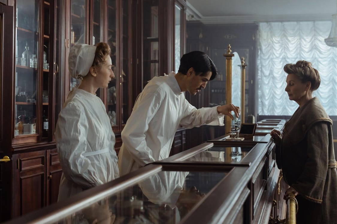 Free A classic vintage pharmacy scene with a pharmacist and customer interacting over a counter. Stock Photo