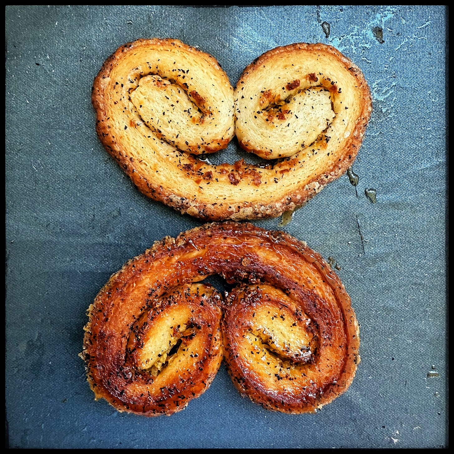 Two lemon zest and Earl Grey tea flecked palmiers, topside up and bottoms side up. 