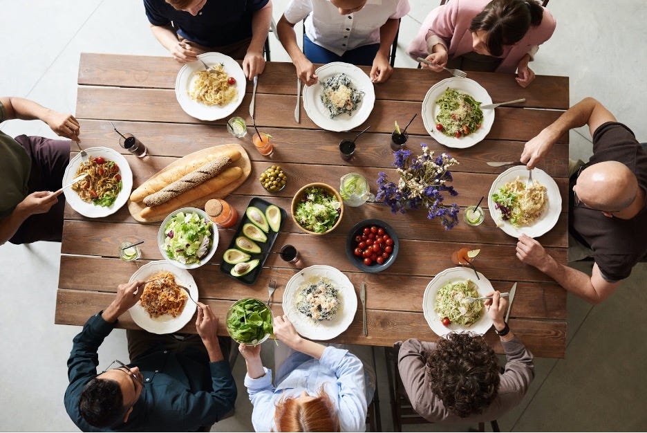 A top-down view of a group of people gathered around a table, sharing a healthy meal