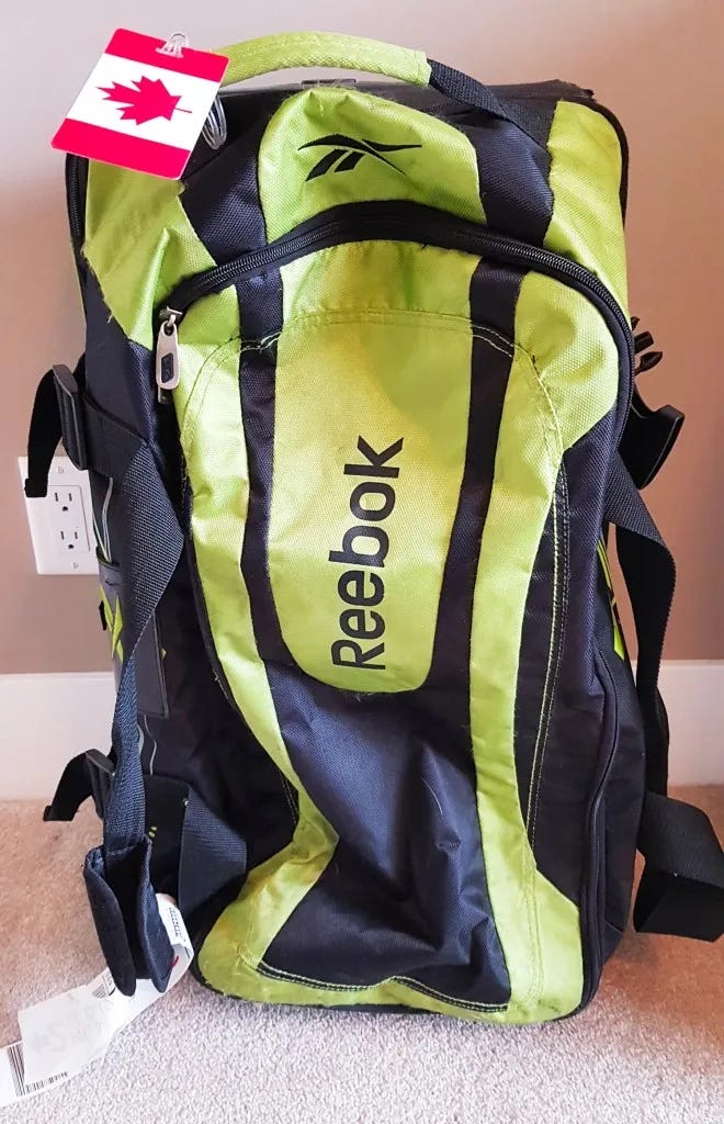 Reebok rolling duffel bag with Canadian baggage tag