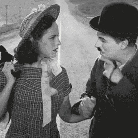 Charlie Chaplin urges Paulette Goddard to smile, in the middle of a long road in the final scene of Chaplin's 1936 film Modern Times - animated gif