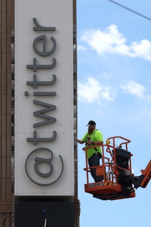 A worker removes letters from the Twitter sign that is posted on the exterior of Twitter headquarters on July 24, 2023 in San Francisco, California.