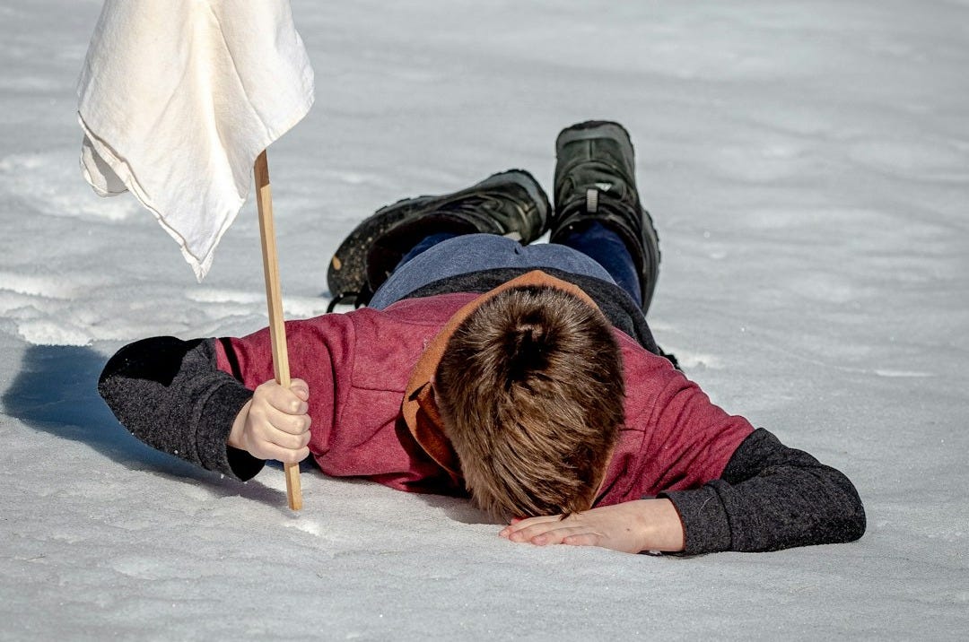 woman in black jacket lying on white snow