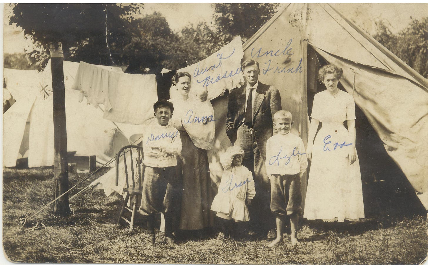 1911 photo postcard of Shinn family standing in front of a large tent