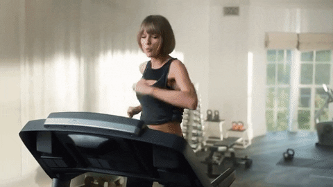 A woman running on a treadmill celebrating then falling on their face.