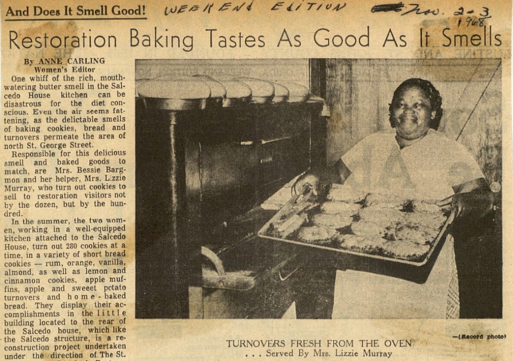 A newspaper article titled "Restoration Baking Tastes As Good As It Smells" featuring a photograph of a woman holding a pan of pastries in front of a large oven.