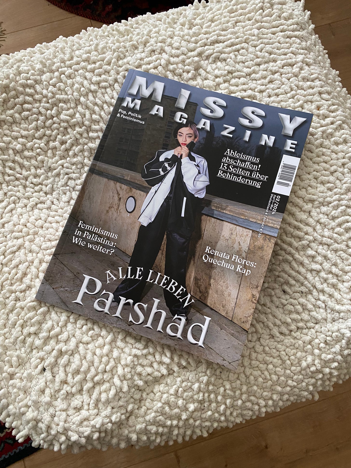 Missy magazine issue laid on a beige pouf. The cover shows the young female entertainer Parshad in a black and white outfit.