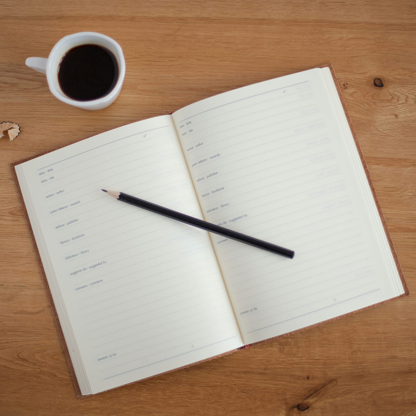 An open notebook next to a cup of coffee