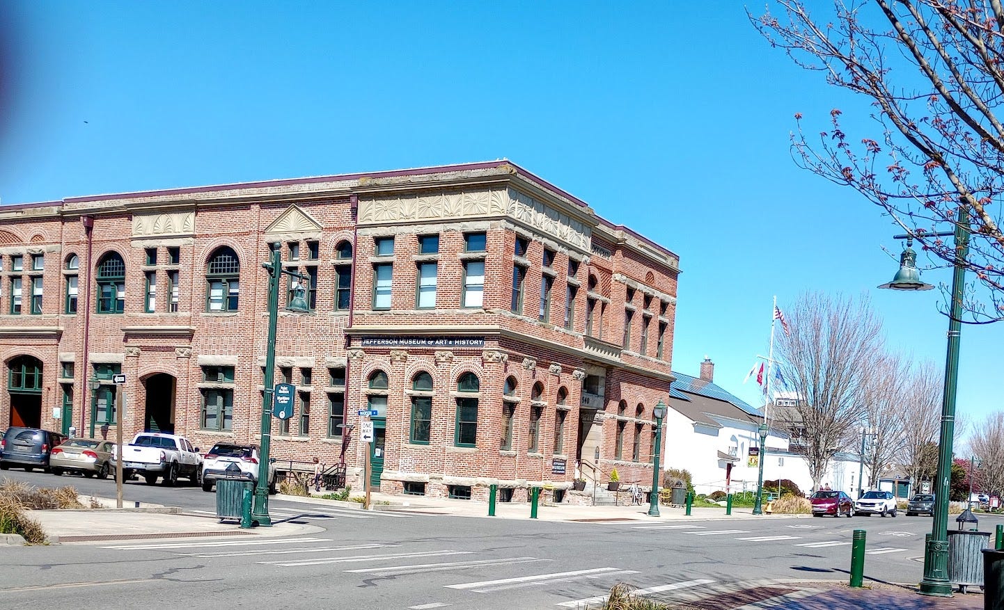 Two story brick building with multiple windows and flat roof