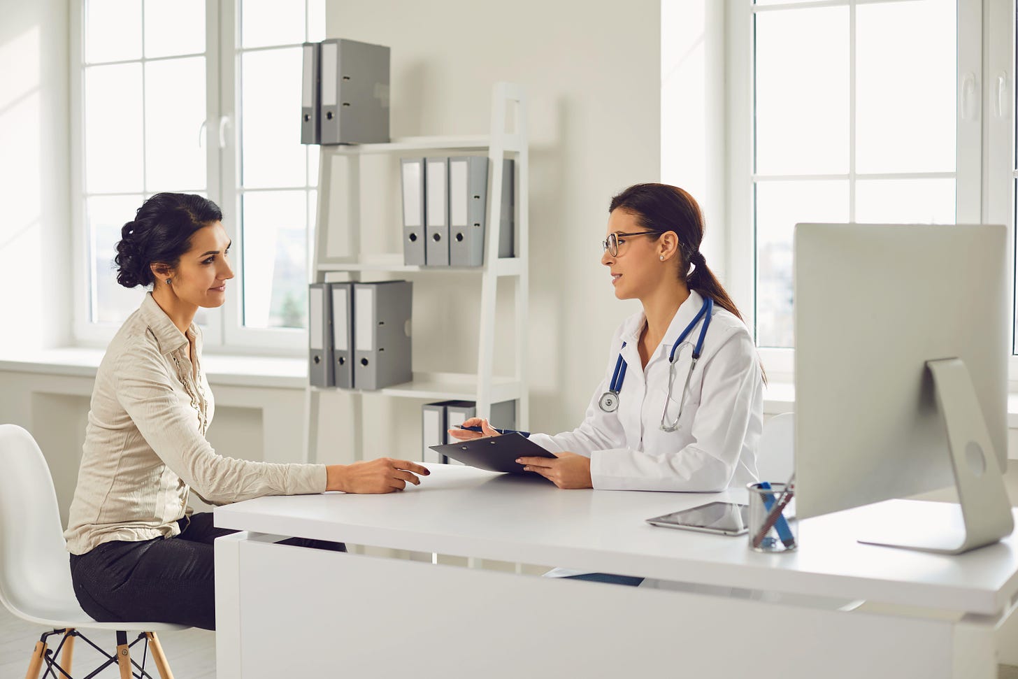 A young woman patient sat down having a discussion with a female doctor in a clinic 