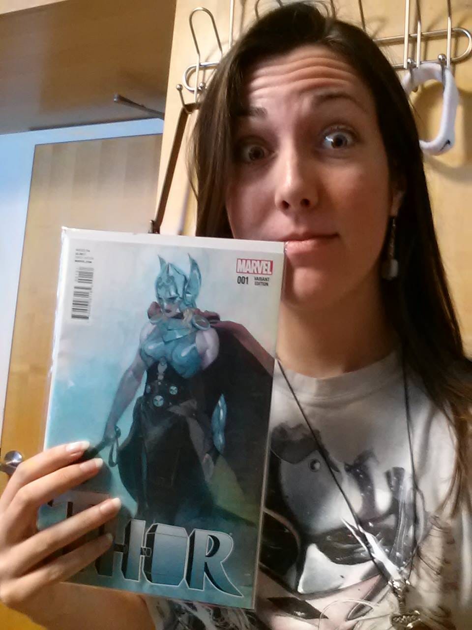 Amy, a brunette girl in her early 20s, posing with the Esad Ribic variant cover of Thor #1 in 2014