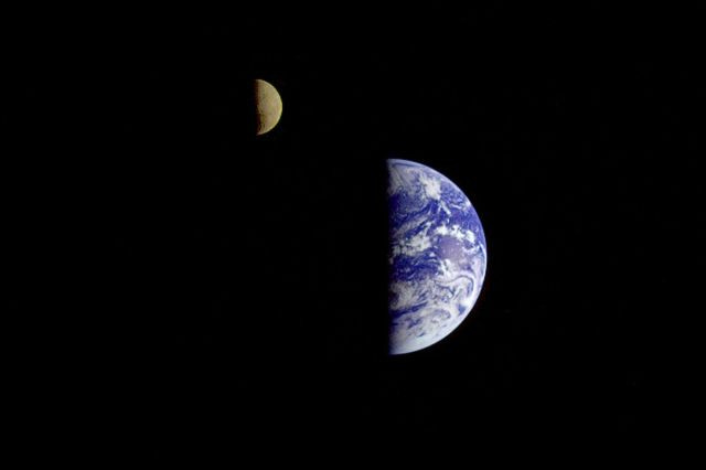 The Earth and the moon, half-illuminated, seen from space.