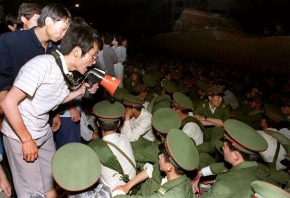 BEIJING, CHINA - JUNE 3:  Using a loudspeaker, a student asks soldiers to go back to their barracks as crowds flooded into the central Beijing 03 June 1989.  On the night of 03 and 04 June 1989, Tiananmen Square sheltered the last pro-democracy supporters as Chinese troops marched on the square to end a weeks-long occupation by student protestors, using lethal force to remove opposition it encountered along the way. Hundreds of demonstrators were killed in the crackdown as tanks rolled into the environs of the square.   AFP PHOTO  (Photo credit should read CATHERINE HENRIETTE/AFP/Getty Images)