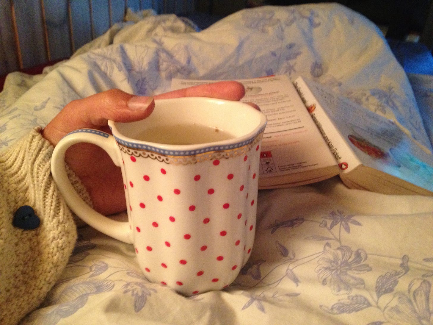 Teetasse im Bett mit Buch