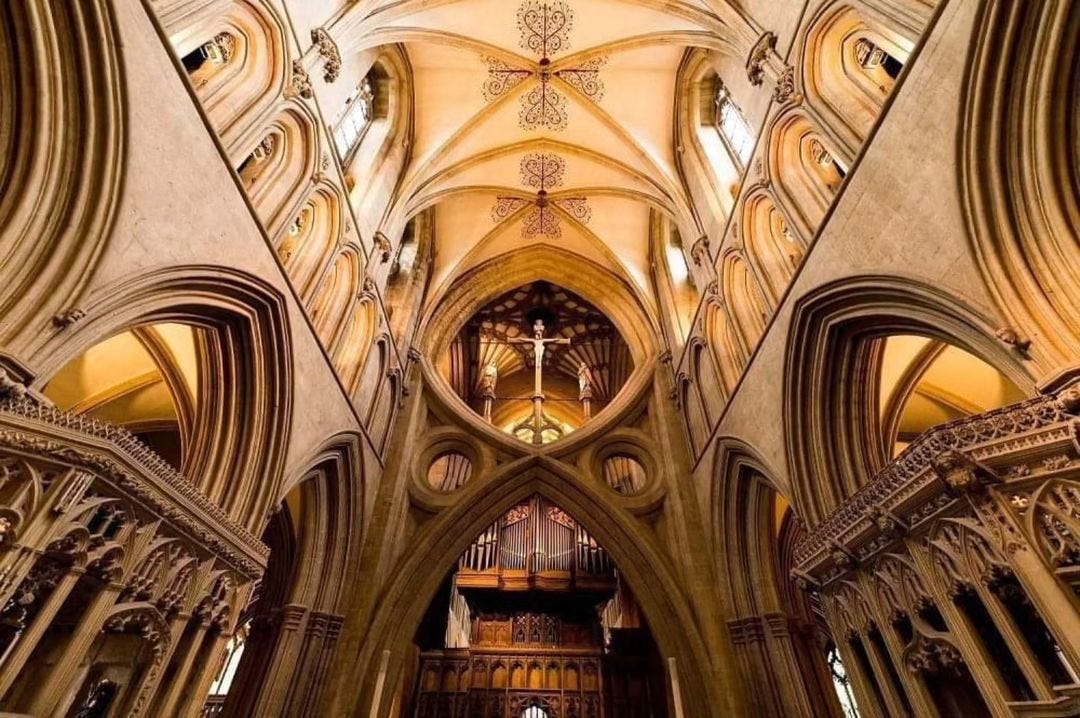 “The scissor arches in Wells Cathedral are one of the most distinctive and innovative architectural features in the cathedral. These unique structural elements are both functional and visually striking, playing a crucial role in the stability of the building. Constructed in the mid-14th century, specifically between 1338 and 1348. They were designed and built by master mason William Joy. The primary purpose of the scissor arches was to reinforce the central tower of the cathedral. The tower, which had been significantly heightened in the early 14th century, began to show signs of instability and threatened to collapse under its own weight. While their primary function is structural, the scissor arches also add a unique visual element to the cathedral’s interior. Their intricate design and dramatic form draw the eye upward, enhancing the sense of height and grandeur within the cathedral.” Photo and caption by Emma Newlan