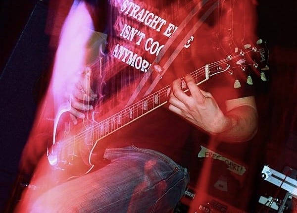 Live photo of Chris Z playing guitar for Paint the Town Red wearing a "Straight Edge isn't cool anymore" T-Shirt
