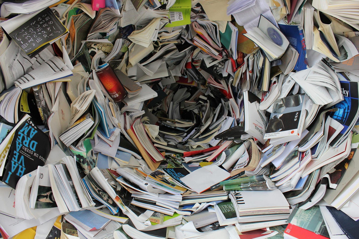 Swirling vortex of random papers and books in chaos. Swirling vortex of random papers and books in chaos.