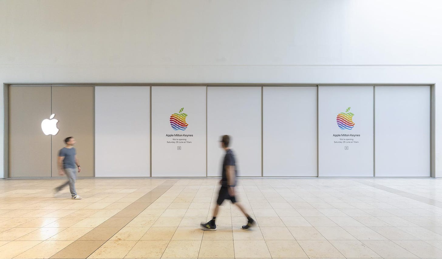 The exterior of the new Apple Milton Keynes. The storefront is covered with vinyl and two heritage logos. The store design style appears to be Vintage E.