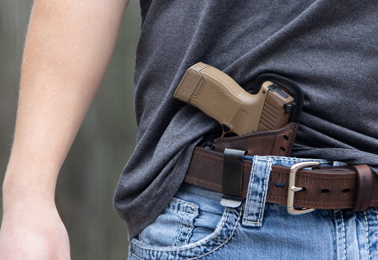 Gun tucked into holster beneath man's belt