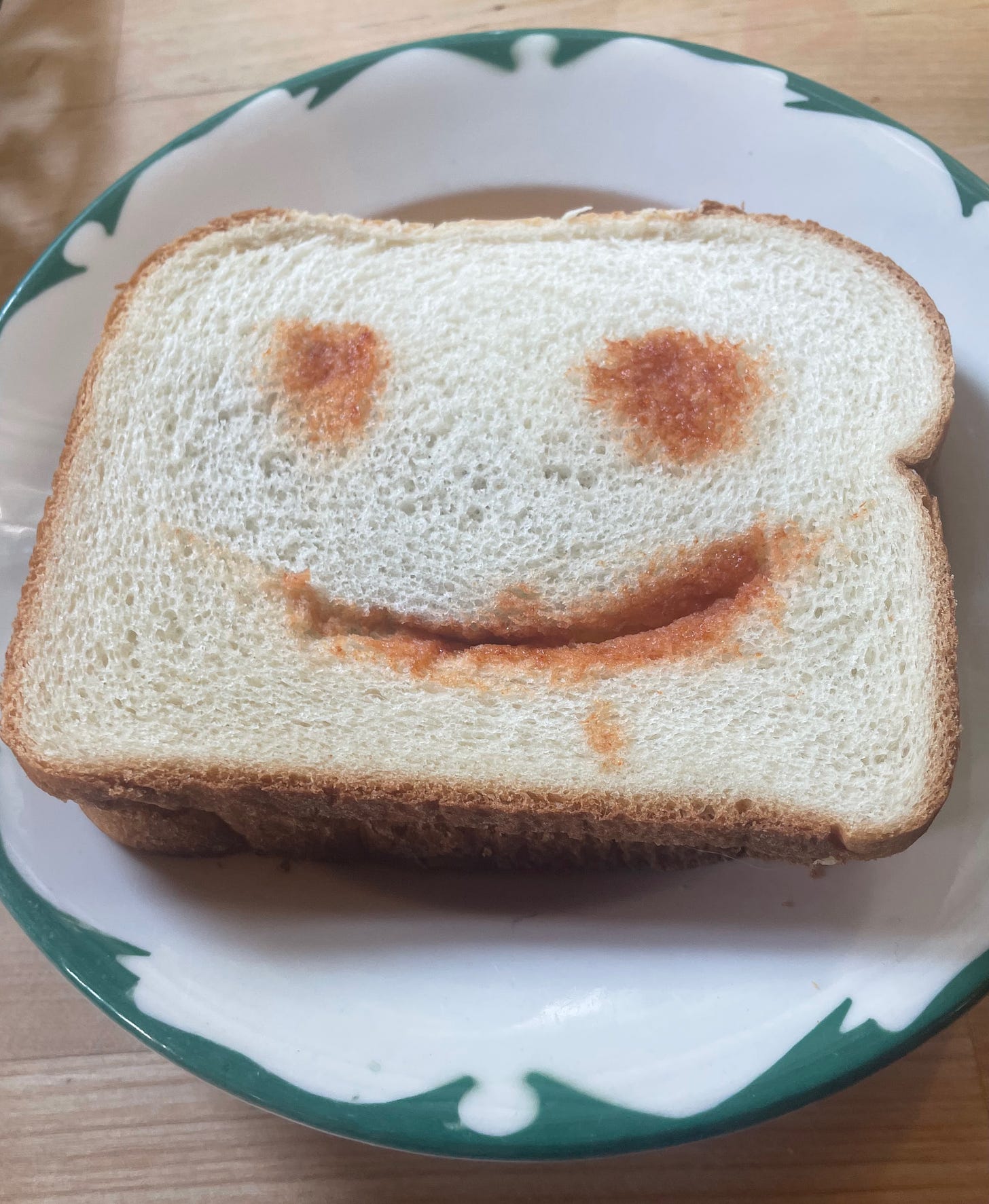 photo of a sandwhich with a smiley face made of ketchup