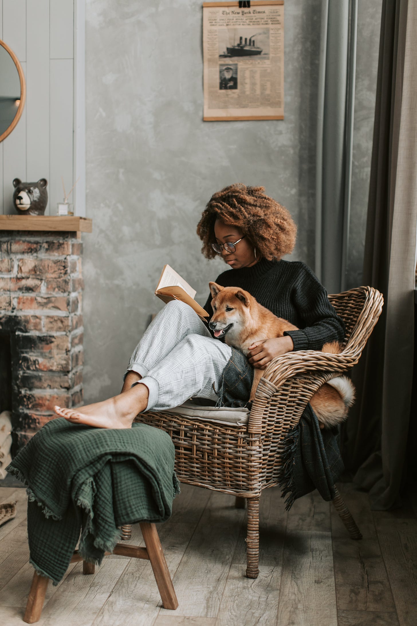 Woman Relaxing at Home While Reading a Book With Her Dog