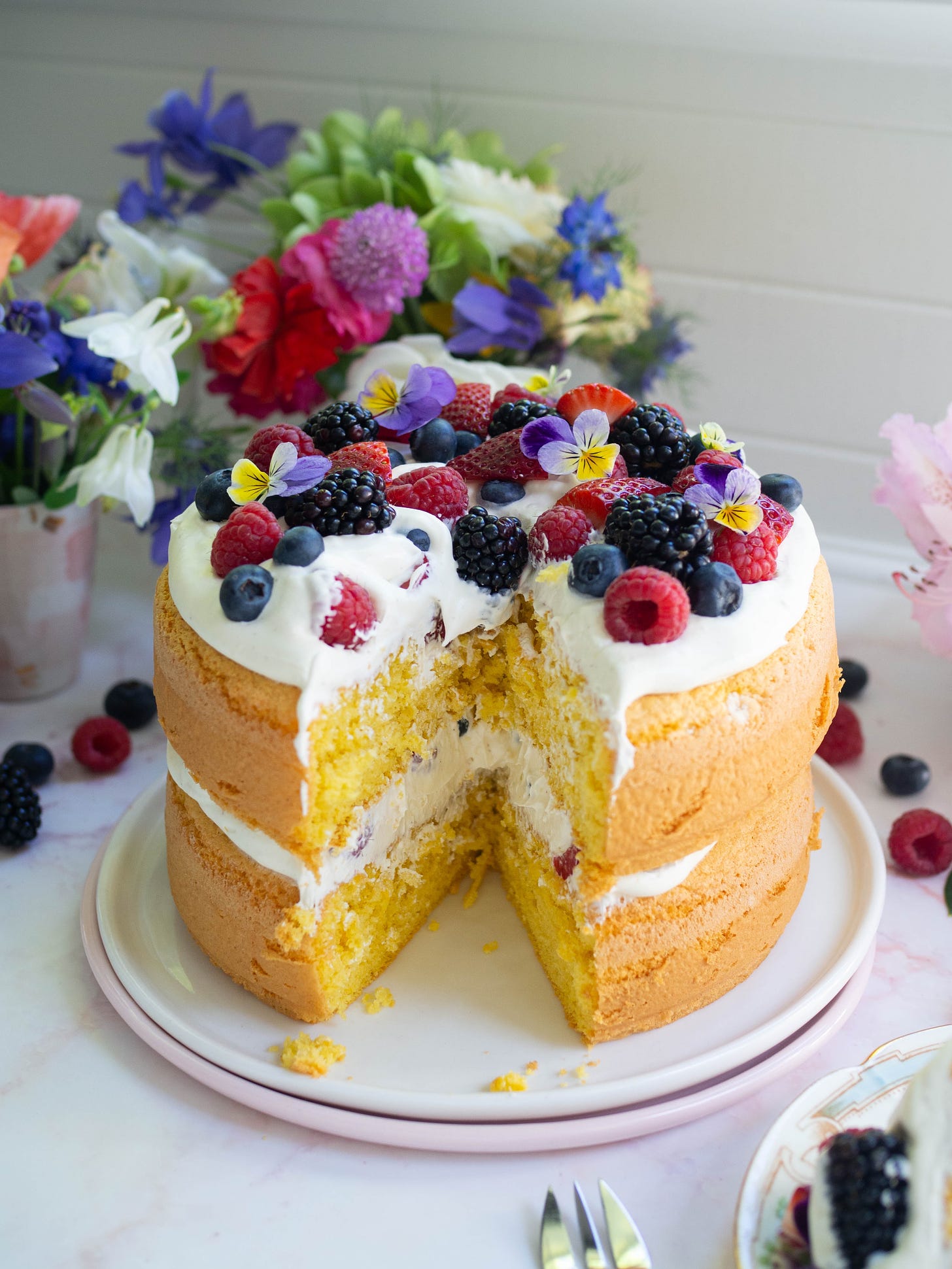 double layer sponge cake with berries slice cut out of cake