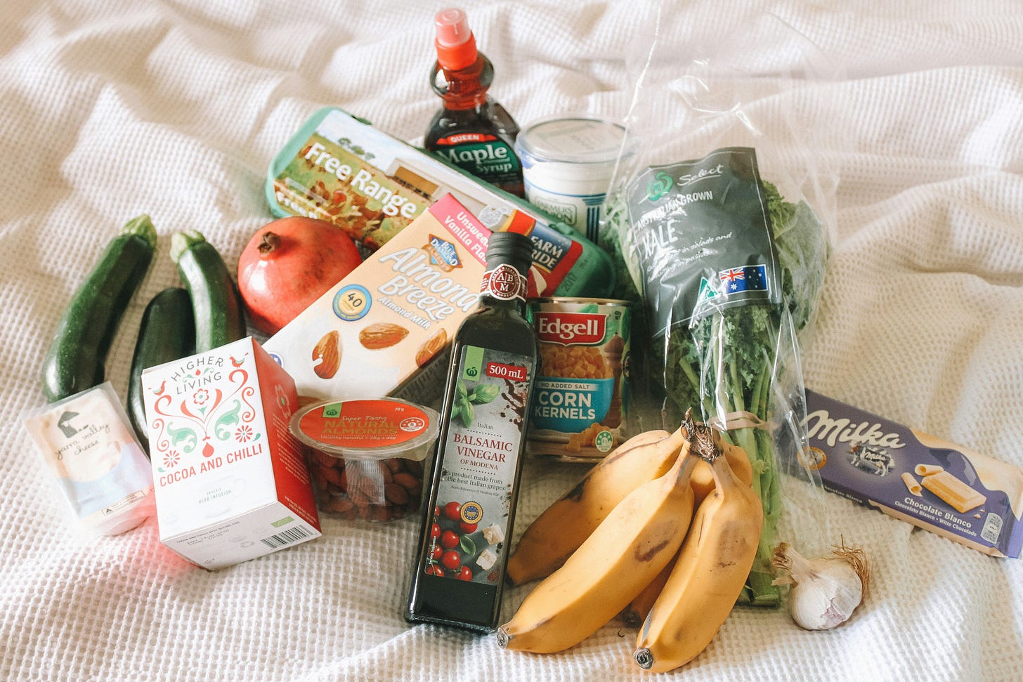 A pile of groceries sits on a white blanket.